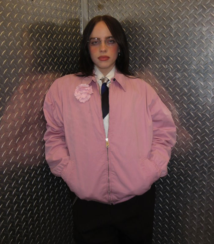 Billie Eilish posing in a pink jacket, showing her slimmed down figure. Billie Eilish posing in a pink jacket, showing her slimmed down figure.