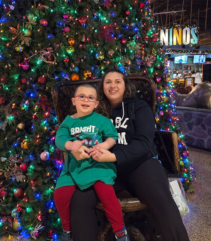 Mother and child sitting by a decorated Christmas tree at family resort