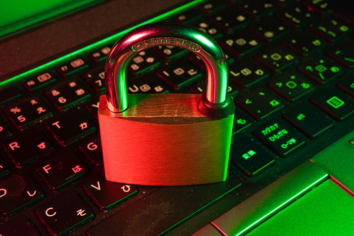 Brass padlock resting on a laptop keyboard symbolising cybersecurity against AI agent swarms. Brass padlock resting on a laptop keyboard symbolising cybersecurity against AI agent swarms.