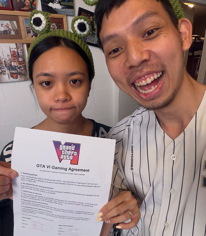 Couple holding a printed gaming agreement, illustrating a husband shamed online for making his wife sign it. Couple holding a printed gaming agreement, illustrating a husband shamed online for making his wife sign it.