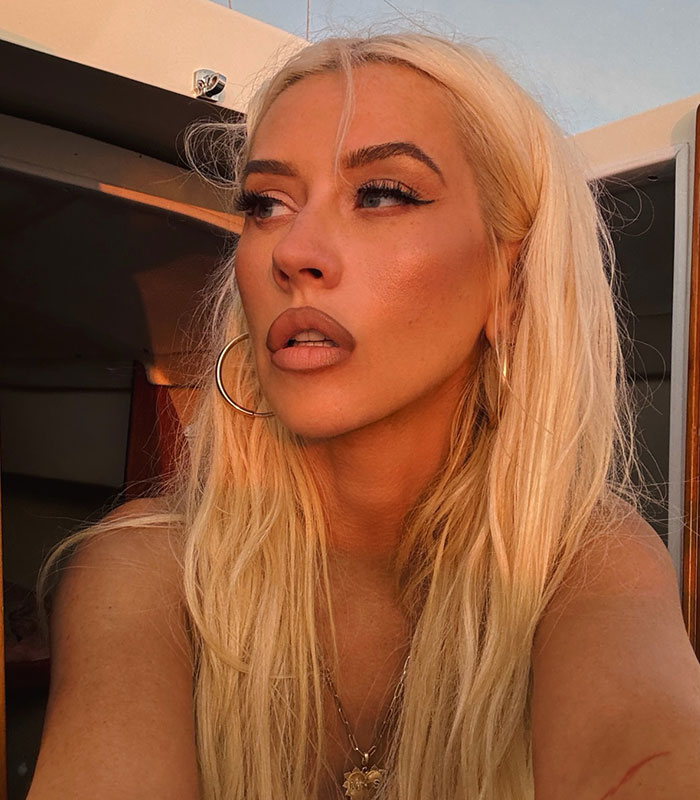 Close-up portrait of Christina Aguilera featuring bold makeup and blonde hair.