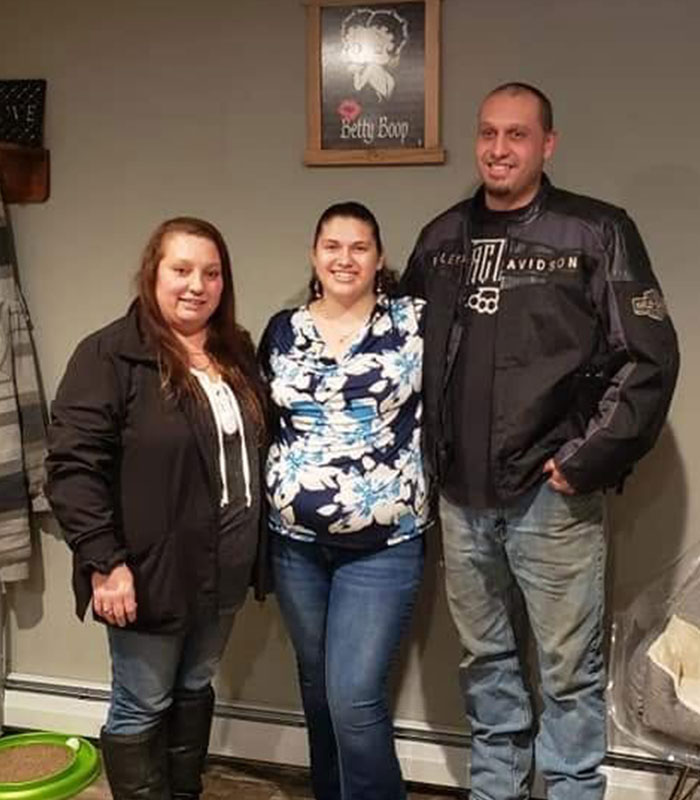 Group photo of three adults posing indoors at family resort