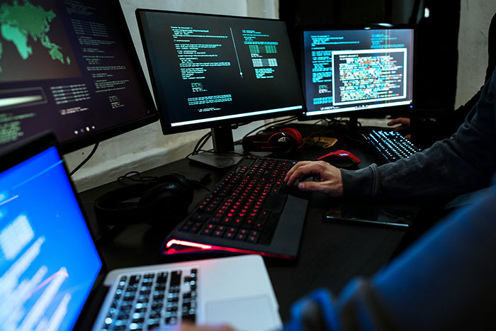 A developer working in a dark room surrounded by computer screens displaying code representing AI agent swarms. A developer working in a dark room surrounded by computer screens displaying code representing AI agent swarms.