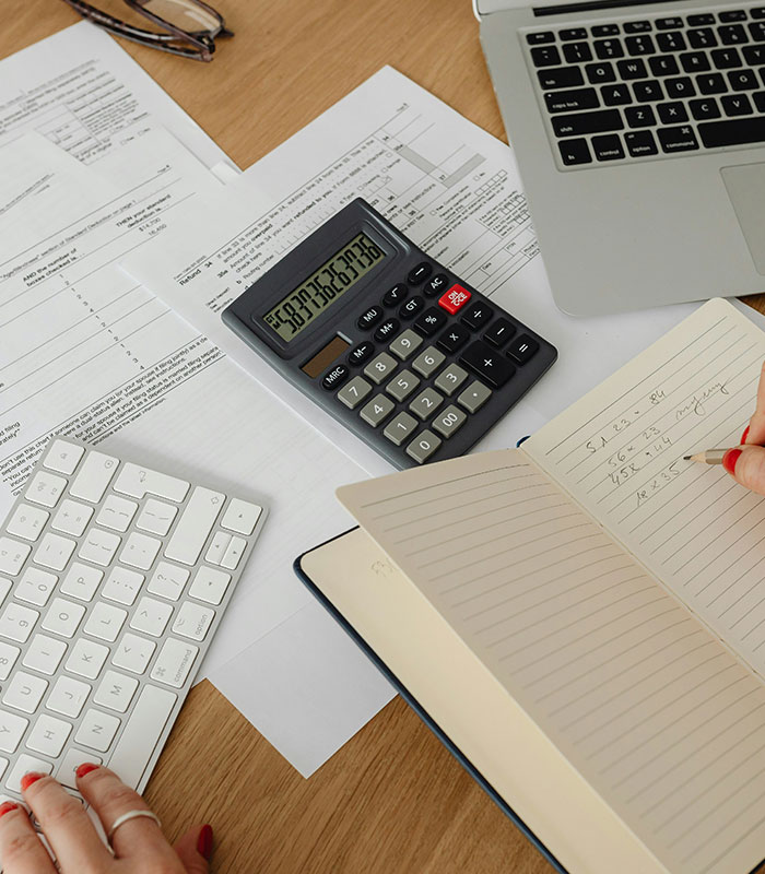 Person working on financial documents and calculator, illustrating issues with requesting a refund from an Airbnb host.