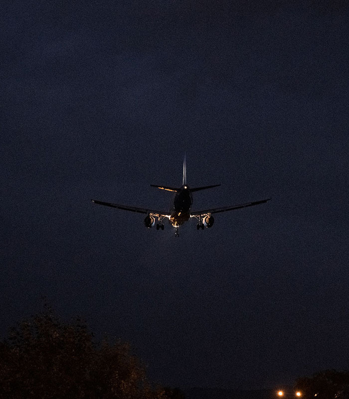 Silhouette of an airplane flying at night, capturing the reality of nighttime flying. Silhouette of an airplane flying at night, capturing the reality of nighttime flying.