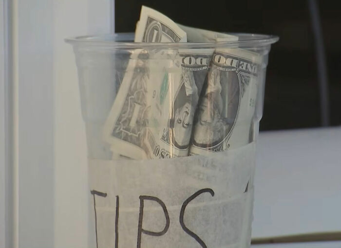 A plastic cup used for tips in an ice cream shop. A plastic cup used for tips in an ice cream shop.