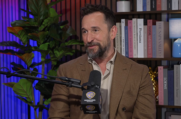 Noah Wyle wearing a suit during a podcast interview