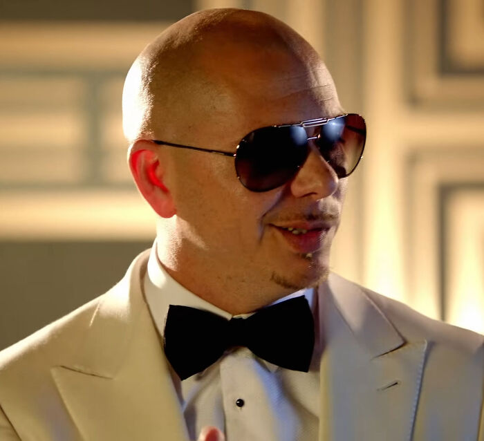 Musician Pitbull in a white suit and sunglasses smiling, associated with his cheeky confession about Jennifer Lopez. Musician Pitbull in a white suit and sunglasses smiling, associated with his cheeky confession about Jennifer Lopez.