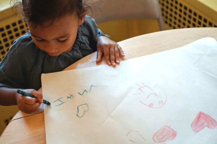 A young child drawing hearts on paper, representing family themes linked to choose divorce decisions.