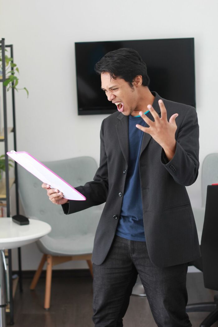 Angry man reading document in office casually admitting disturbing things