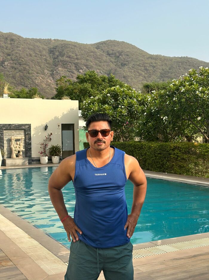 Man posing by pool with mountains in background for seriously disturbing things topic