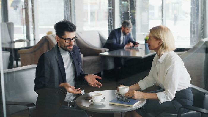 Businesspeople discussing seriously disturbing things during meeting at cafe