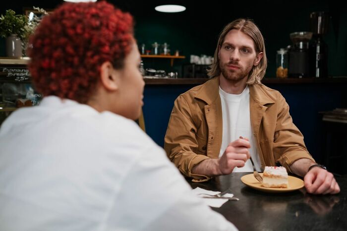 Two people in cafe having intense conversation about seriously disturbing topics