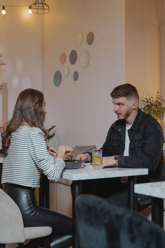 A couple having an intense conversation at a restaurant table contemplating divorce