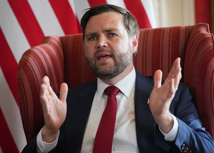 Politician JD Vance speaking passionately with hand gestures in front of an American flag. Politician JD Vance speaking passionately with hand gestures in front of an American flag.