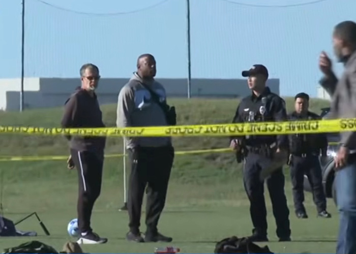 Police and officials at youth soccer field investigating incident with caution tape Police and officials at youth soccer field investigating incident with caution tape