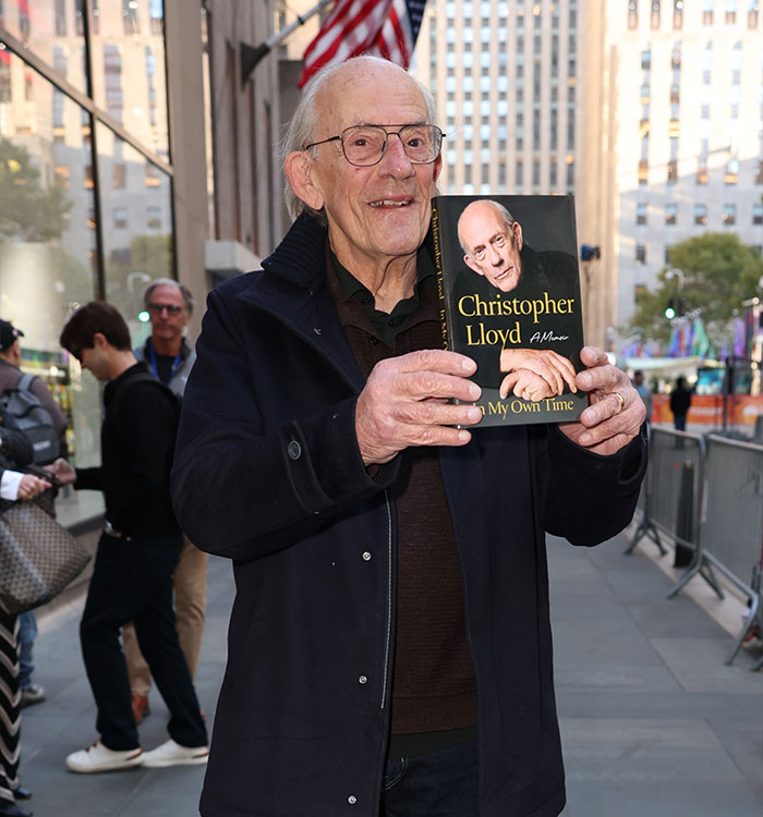Actor Christopher Lloyd holding his memoir book outdoors. Actor Christopher Lloyd holding his memoir book outdoors.