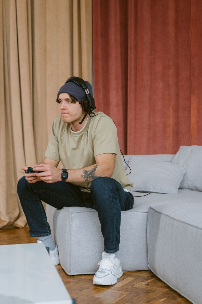 Man playing video games alone on the sofa, oblivious to problems leading his spouse to choose divorce
