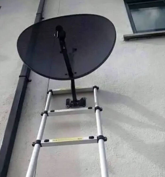 A satellite dish dangerously mounted to a ladder in a failed home improvement attempt.