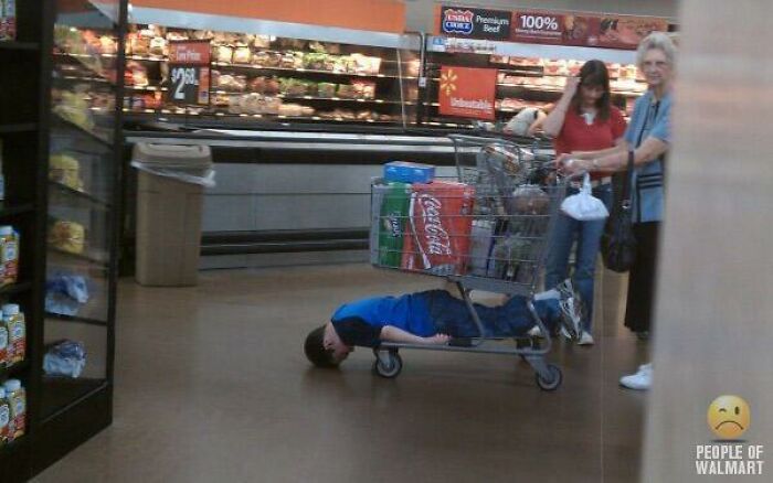 Child lying face down in Walmart shopping cart with adults nearby