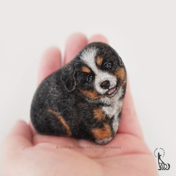 Detailed stone art of a small adorable dog held in hand