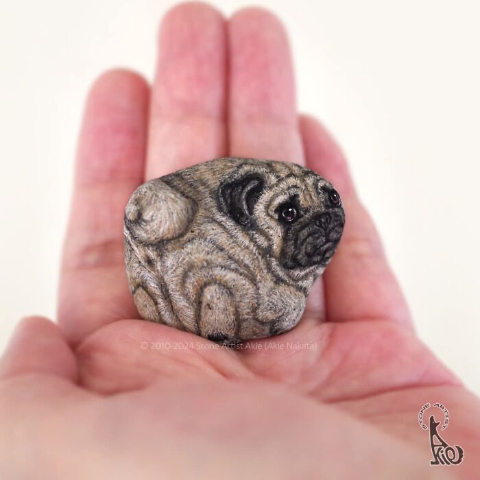 Japanese artist's dog painting on stone held in hand