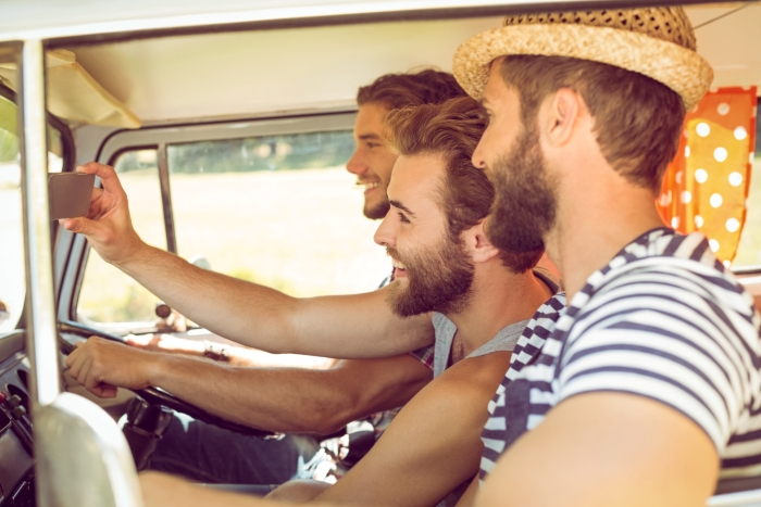 Three men smiling during an Australia trip road trip in a camper van. Three men smiling during an Australia trip road trip in a camper van.