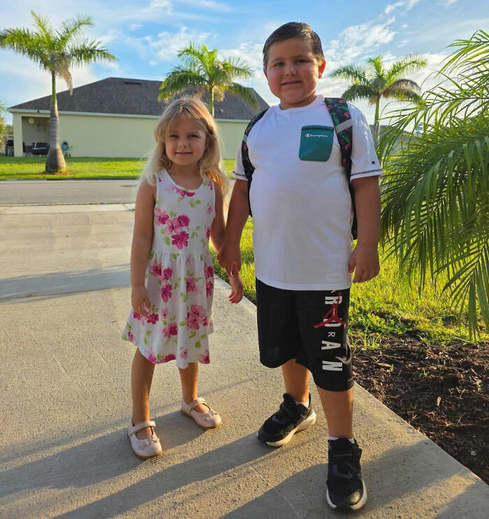 Mom picking up her 2 children featured in a photo of a young boy and girl standing together outside
