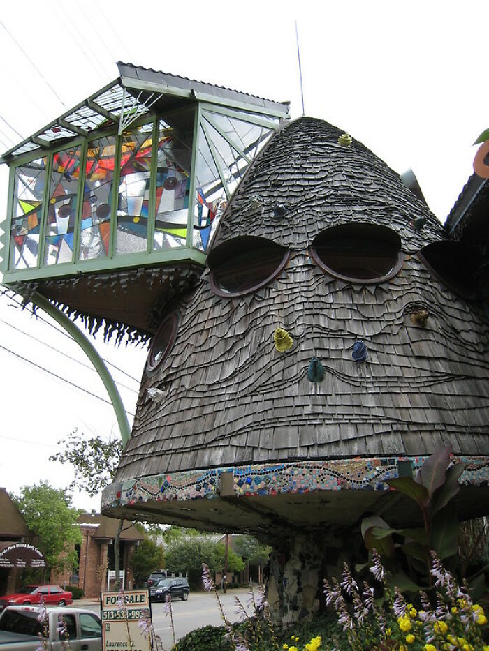 Weird strange building with a wooden shingle tower and colorful glass panels
