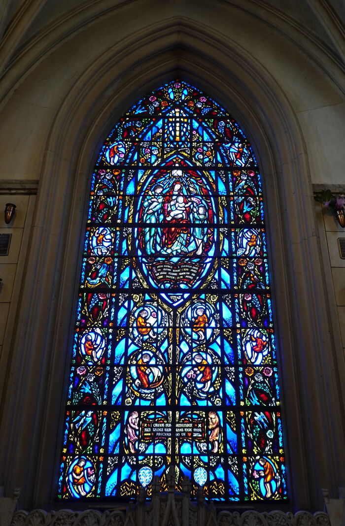Intricate stained-glass window depicting religious scenes in vibrant blue and red hues Intricate stained-glass window depicting religious scenes in vibrant blue and red hues