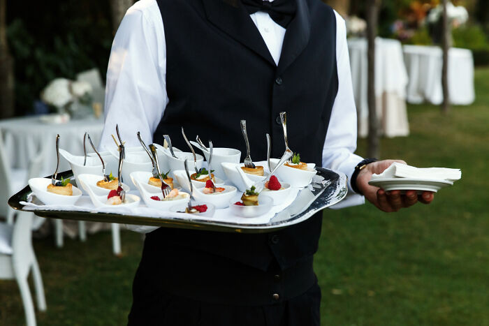 A waiter carrying a tray of snacks, related to obvious lies.