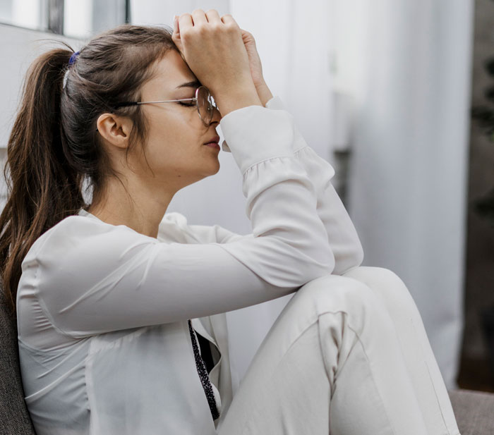 Woman in white looking distressed illustrating impact of cheating and phone tracking Woman in white looking distressed illustrating impact of cheating and phone tracking