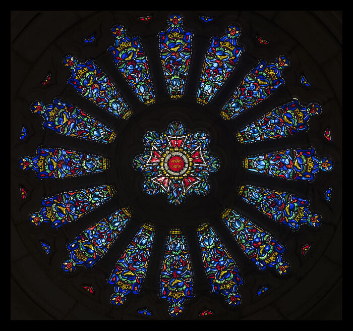 Circular stained-glass rose window with detailed floral patterns and bright colors Circular stained-glass rose window with detailed floral patterns and bright colors