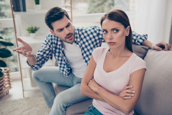 An angry man arguing with a frustrated woman on a couch, showing why this couple fights over cashews and olive oil. An angry man arguing with a frustrated woman on a couch, showing why this couple fights over cashews and olive oil.