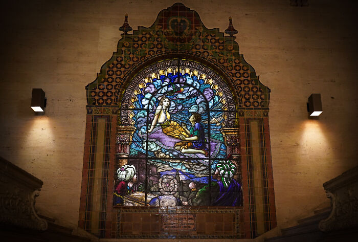 Artistic stained-glass panel featuring two figures surrounded by decorative tiles Artistic stained-glass panel featuring two figures surrounded by decorative tiles
