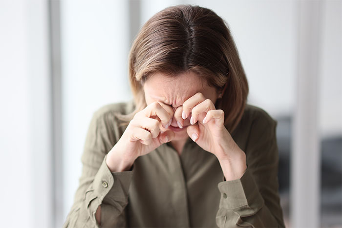 Woman rubbing eyes for relief causing eye strain Woman rubbing eyes for relief causing eye strain
