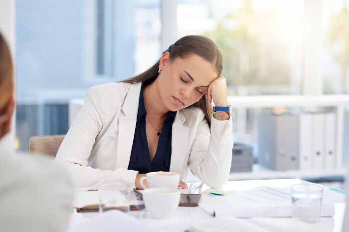 An exhausted businesswoman with closed eyes, illustrating career breaking point moments