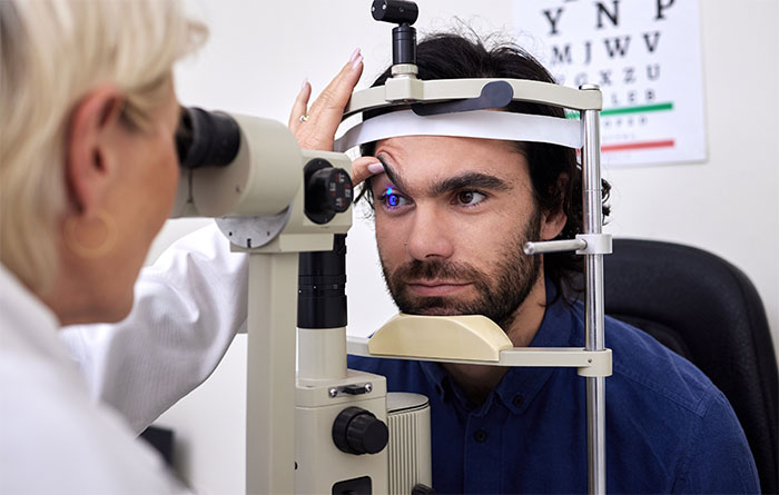 Eye doctor examining patient with eye test machine Eye doctor examining patient with eye test machine