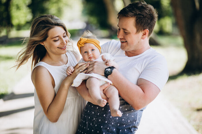 Happy family with a baby outdoors, contrasting with emotional divorce stories of broken homes.