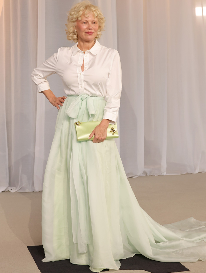 White blouse paired with mint green skirt and clutch at Academy Museum Gala