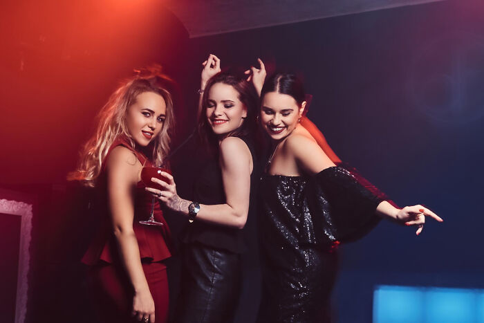 Three friends dancing at a club night out, highlighting personal safety and emergency tips.