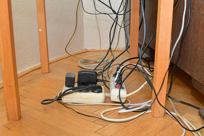 Messy tangle of electrical cords plugged into power strips