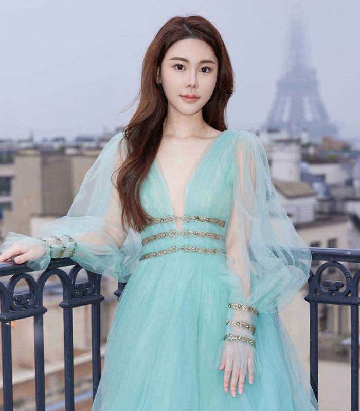 Woman wearing blue tulle gown posing outdoors with Eiffel Tower Woman wearing blue tulle gown posing outdoors with Eiffel Tower