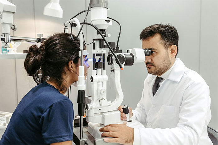 Eye doctor examining patient with slit lamp in eye care clinic Eye doctor examining patient with slit lamp in eye care clinic