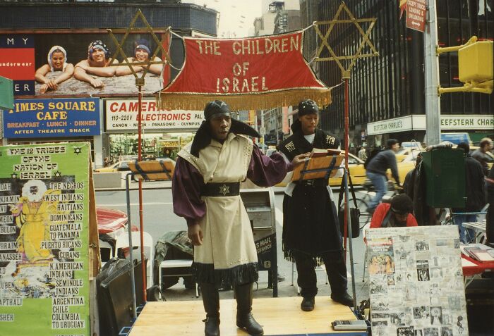 Members of a religious group street preaching in robes, representing lesser-known cults operating today.