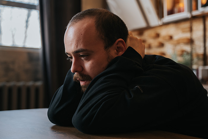 A worried husband resting his head on his arms as he senses something is off after his wife's girls' trip