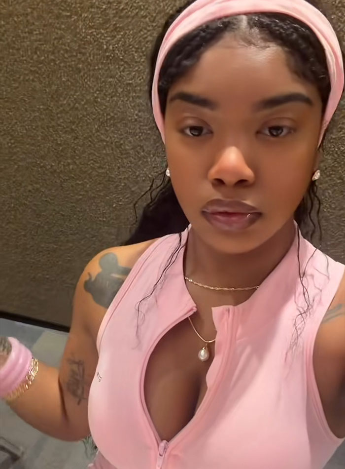 A tourist woman in a pink top poses for a selfie