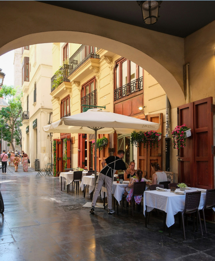 Waiter serving customers at an outdoor European restaurant for a dining out experience. Waiter serving customers at an outdoor European restaurant for a dining out experience.