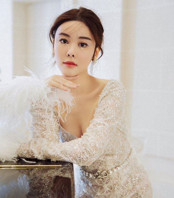 Woman in white feathered dress with detailed embroidery Woman in white feathered dress with detailed embroidery