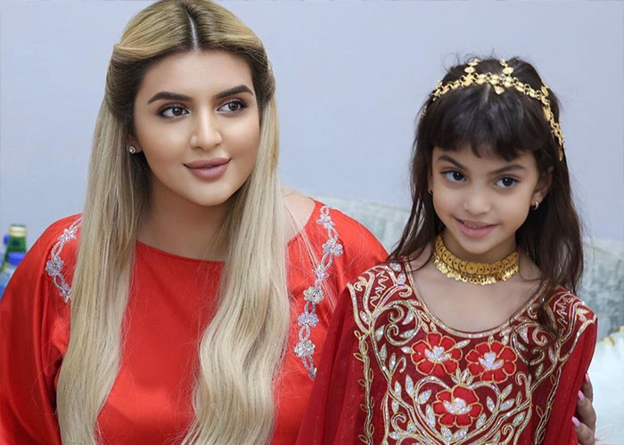 Royal mother and barefoot child wearing traditional clothing together
